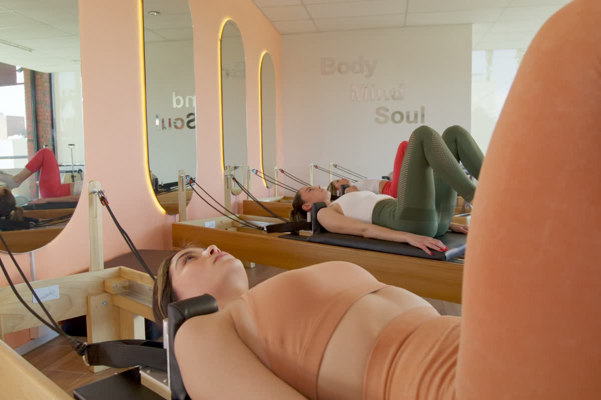 Una lezione di pilates reformer in uno studio luminoso