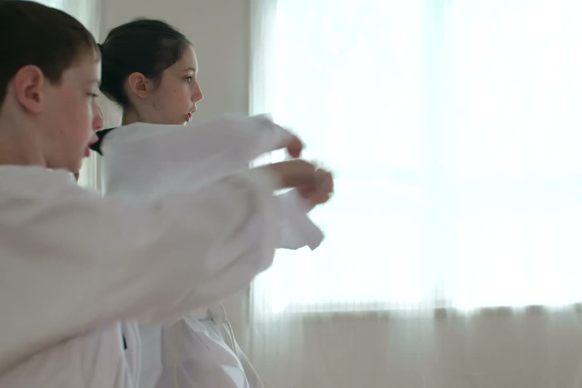 Due ragazzi in kimono con cintura gialla si salutano con l’inchino in una sala luminosa