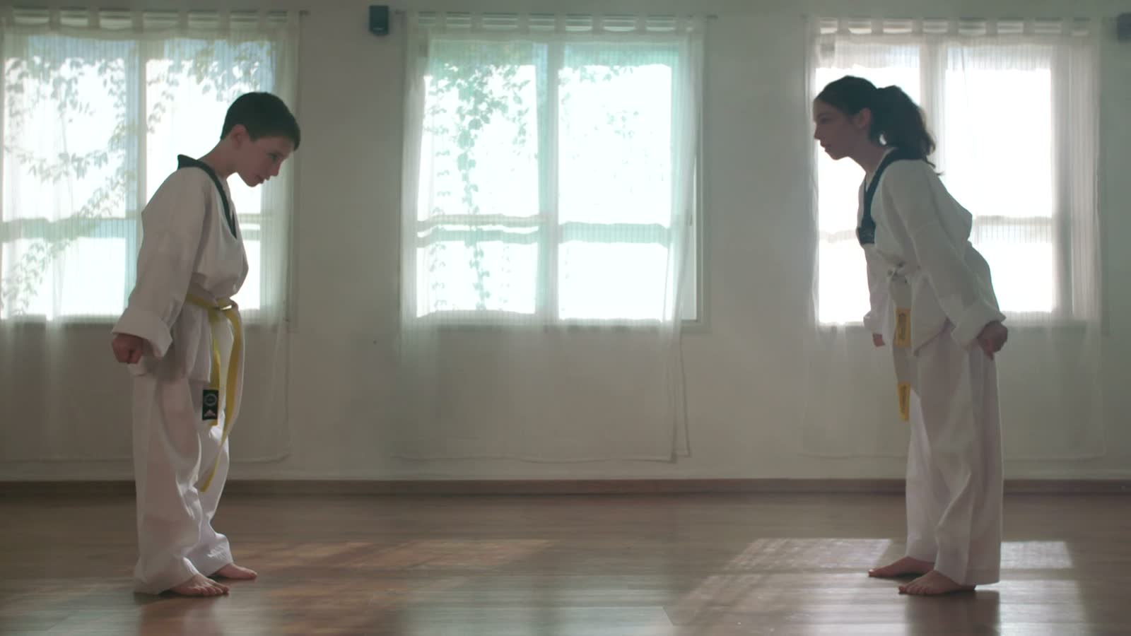 Due bambini in dobok bianco tirano un pugno durante un allenamento di arti marziali